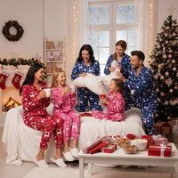 Family in matching pajamas celebrating Christmas in a decorated living room.
